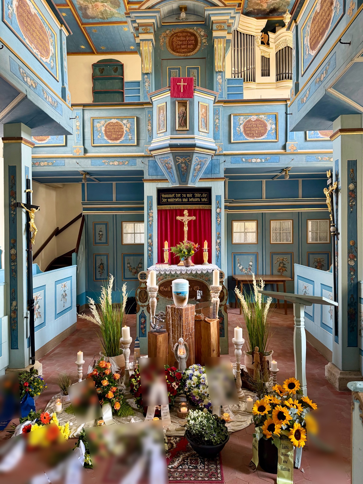 Persönliche Dekoration mit Blumen, Kerzen und Urne vor dem Altar der Kirche Dobraschütz