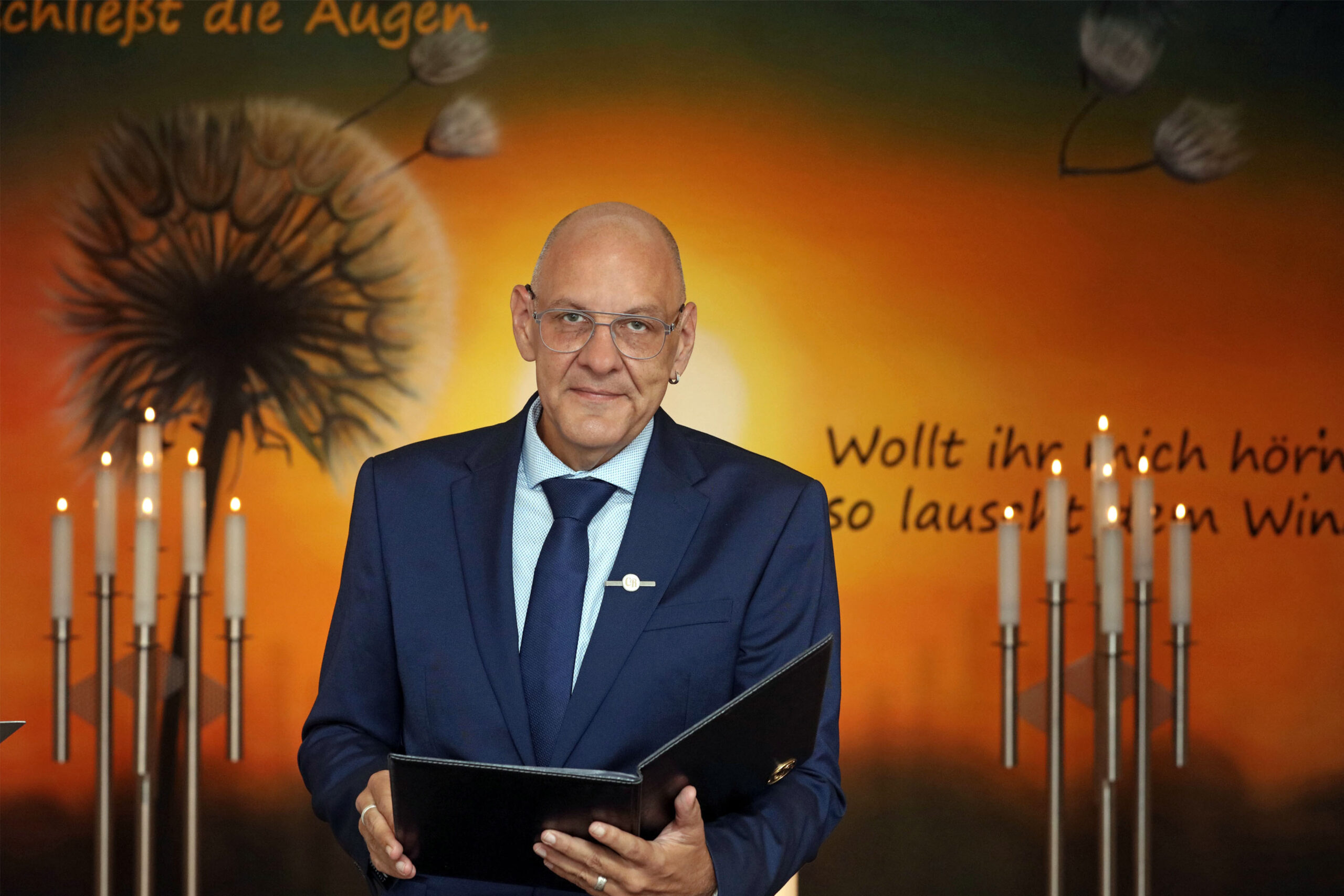 Trauerredner Carsten Riedel mit Redemappe bei einer Trauerfeier