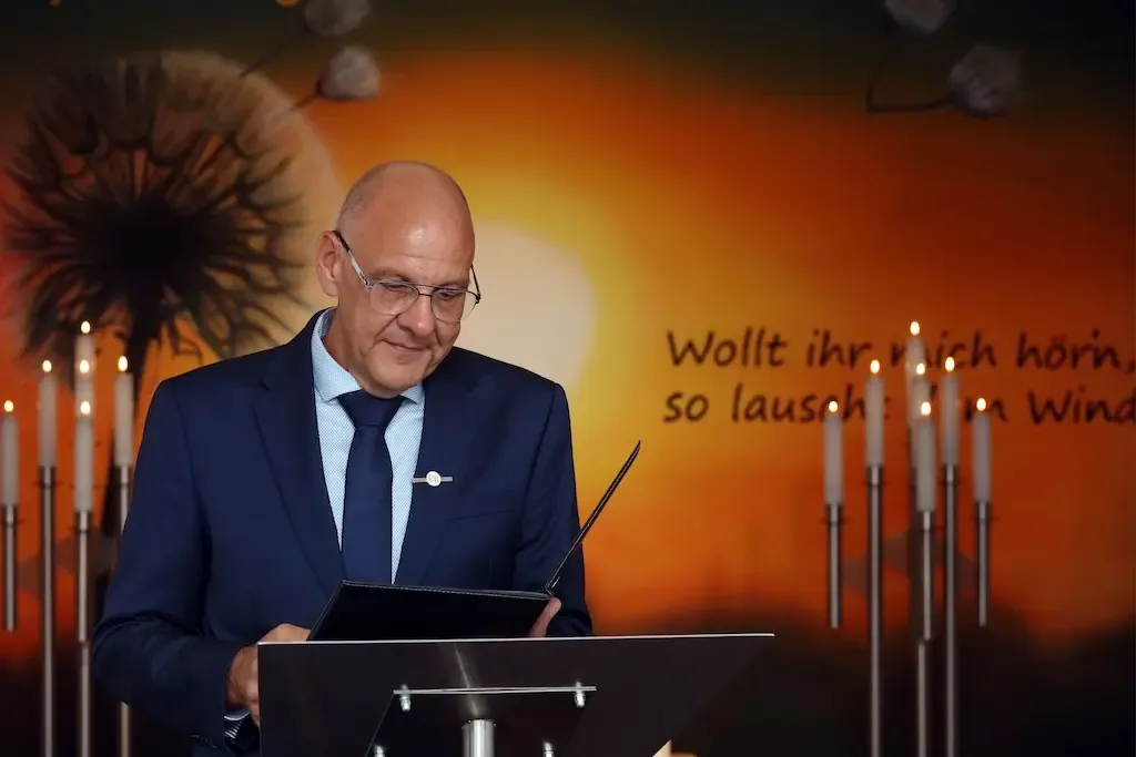 Trauerredner Carsten Riedel am Rednerpult während einer Trauerfeier