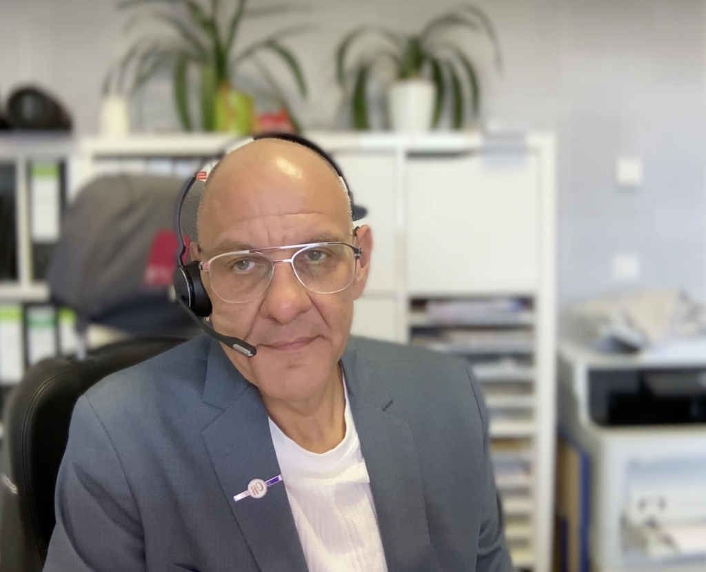 Trauerredner Carsten Riedel im Büro bei einem Gespräch mit Headset
